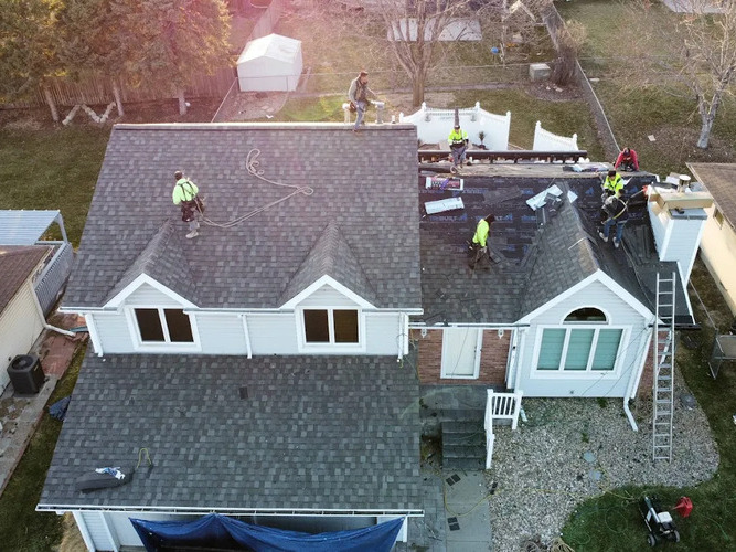 overhead view of workers on a shingle roof