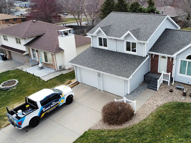 roofing truck next to a home with a shingle roof
