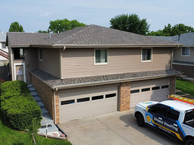roofing truck in front of a home with an asphalt shingle roof